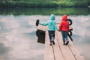 two children on a pier holding hands