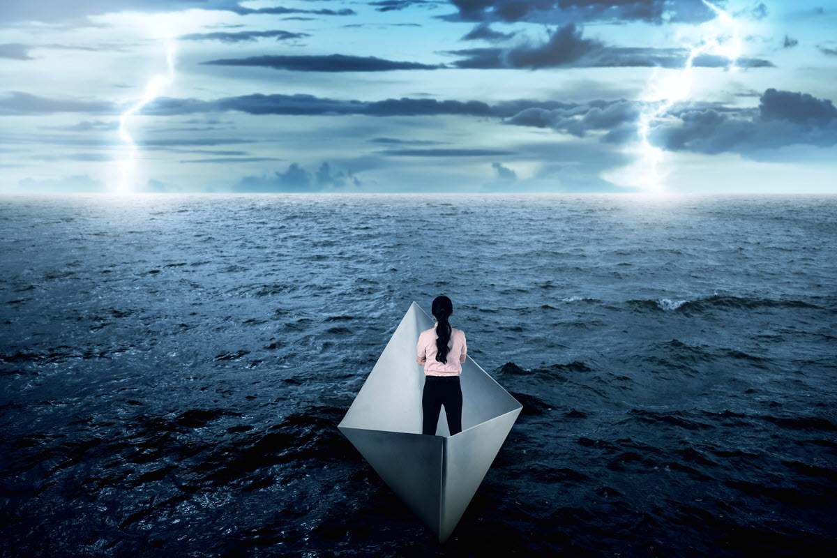 Woman in a paper boat during a storm